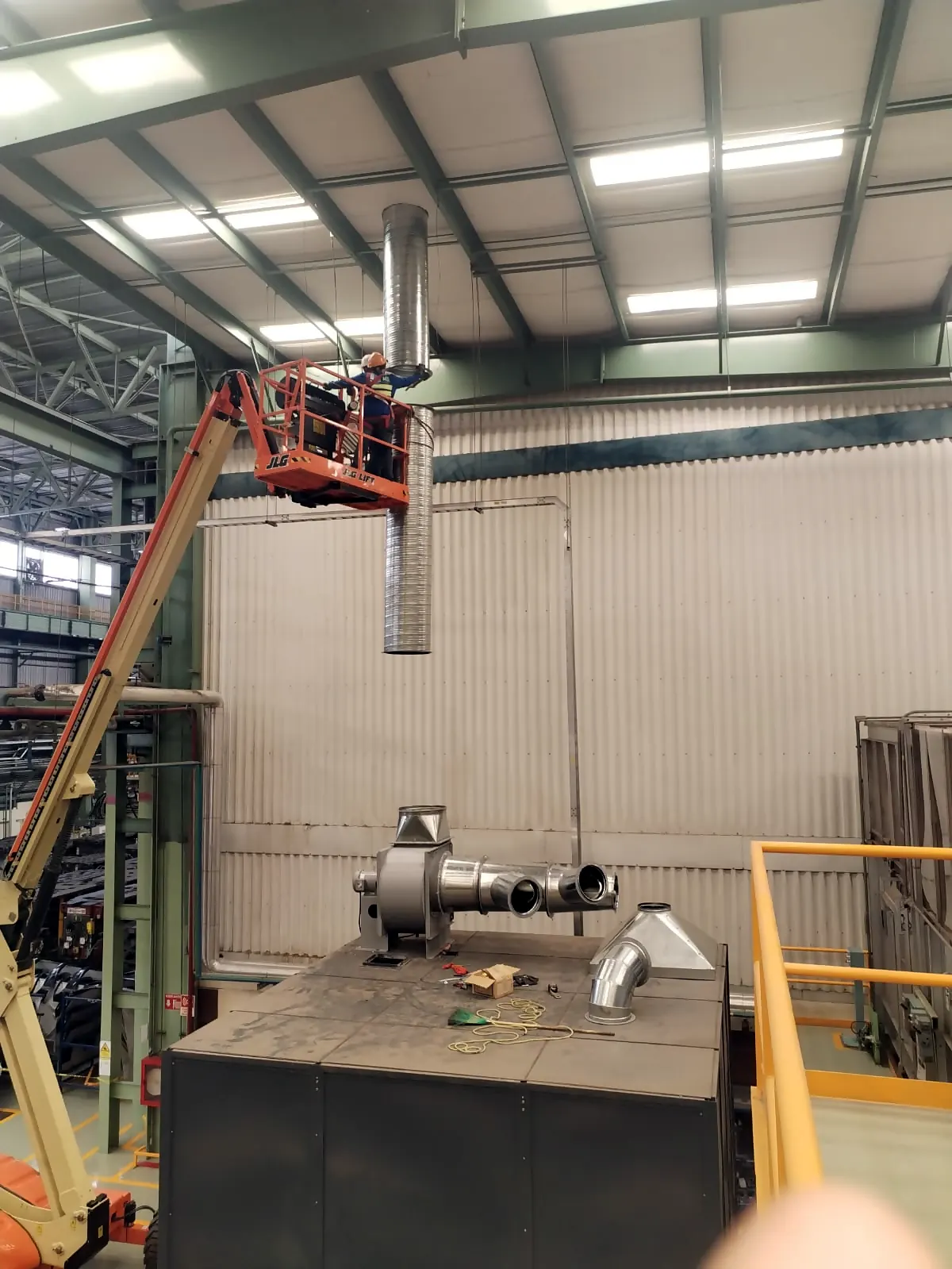 Plataforma elevadora sosteniendo el ducto sobre el extractor